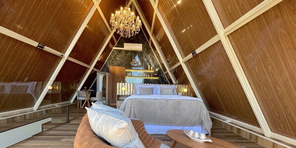 Un interior con cama, zona de estar y candelabro.