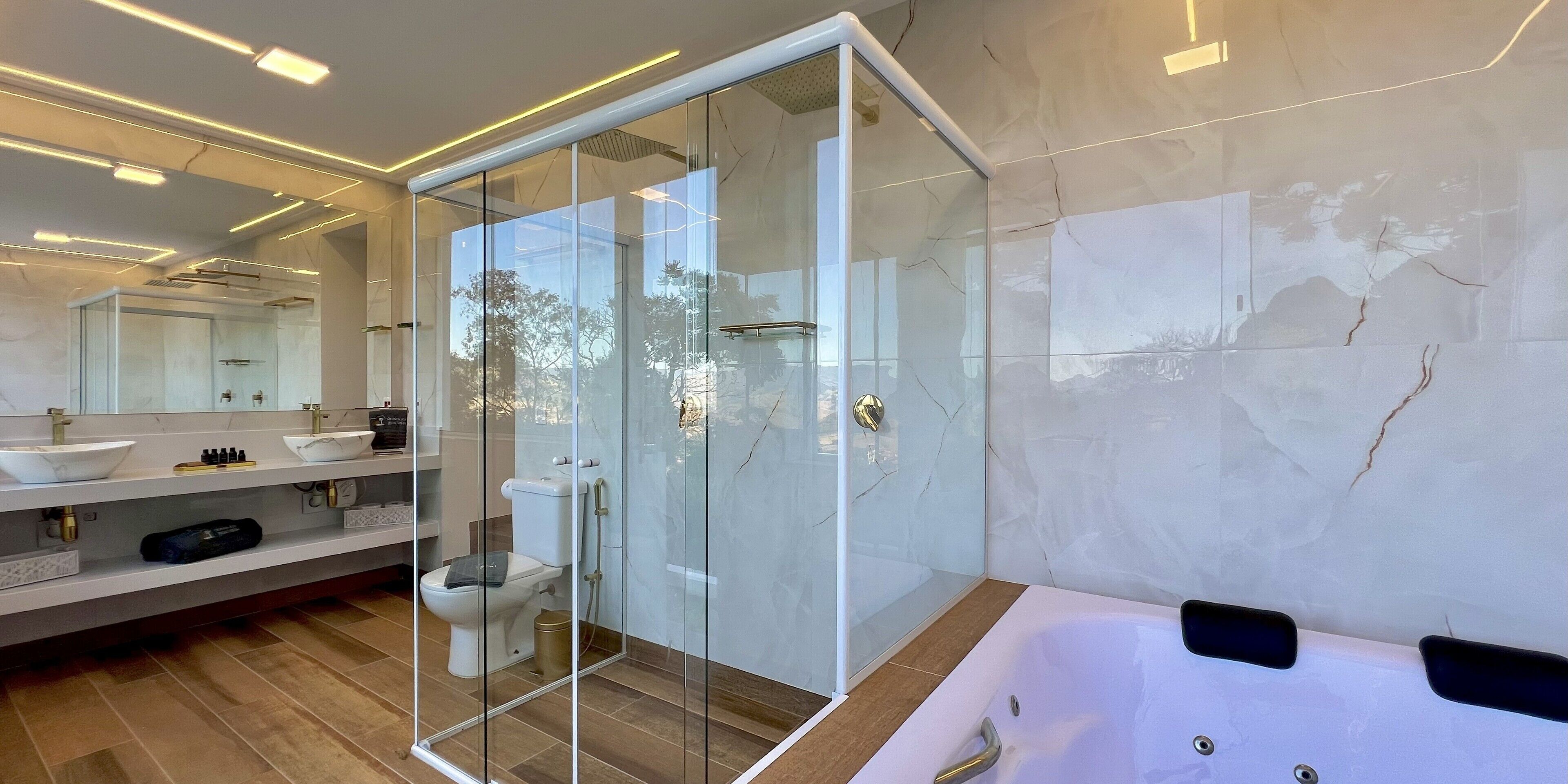 A modern bathroom with a glass-enclosed shower, a large bathtub, and a vanity with a sink and mirror.