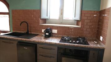 A kitchen with a sink, stove, and dishwasher.