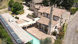 A traditional stone building with a tiled roof, a swimming pool, and a covered outdoor area. - Corte Fratini Residenza D'Epoca (Trevi)