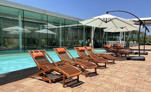 Een seizoensgebonden buitenzwembad en parasols bij het zwembad