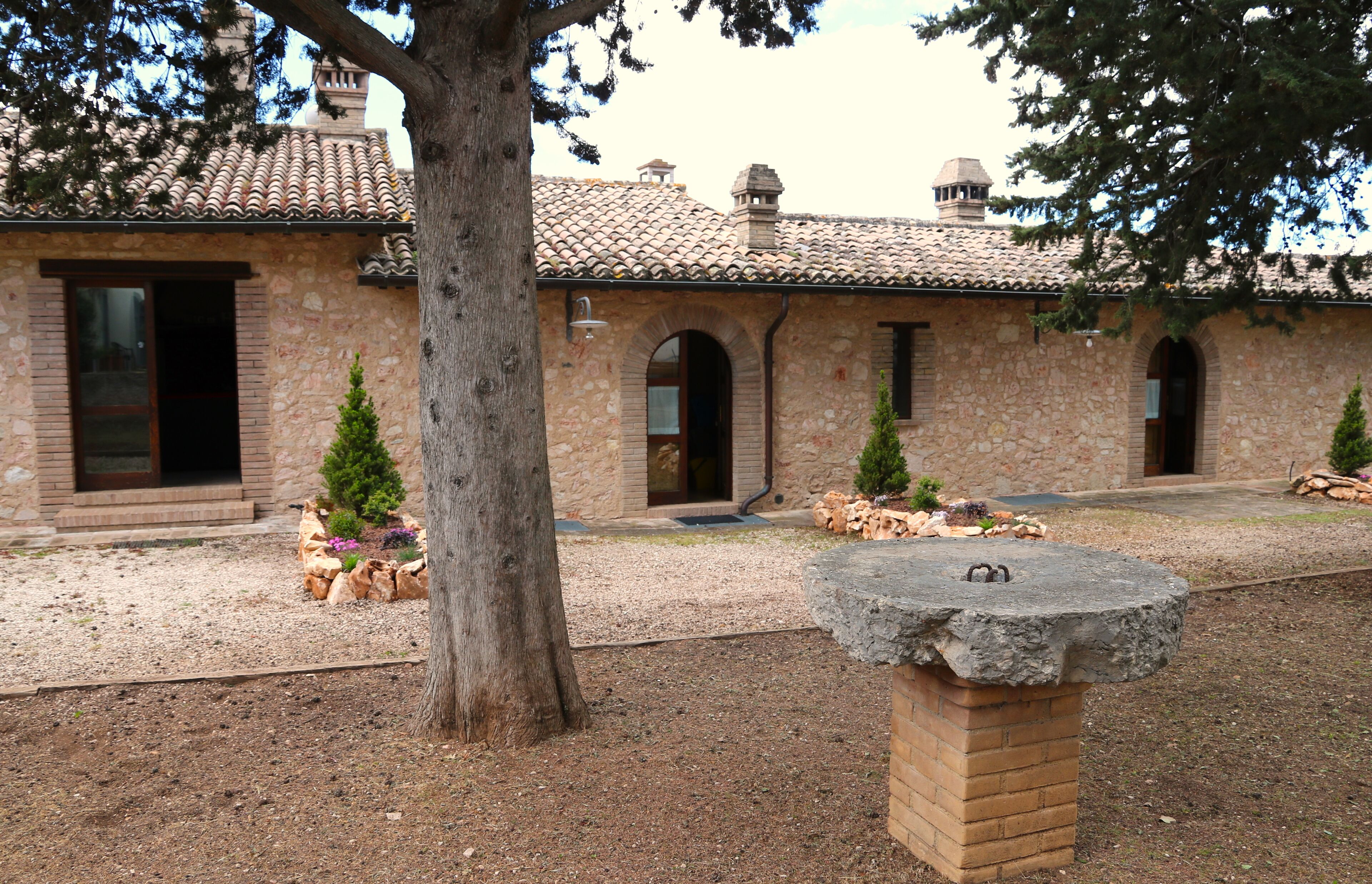 A stone building with arched doorways and a tiled roof.