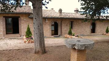 A stone building with arched doorways and a tiled roof.