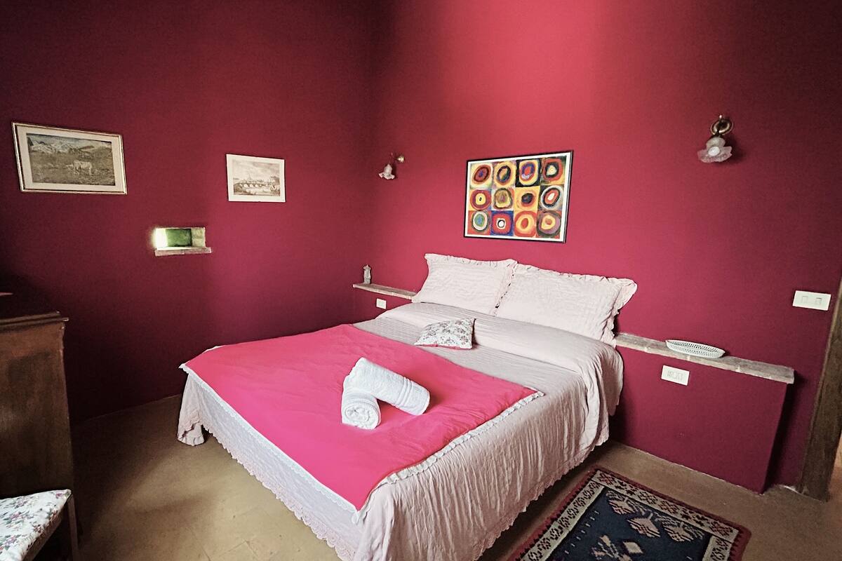 Un dormitorio con cama, cómoda, silla y alfombra.