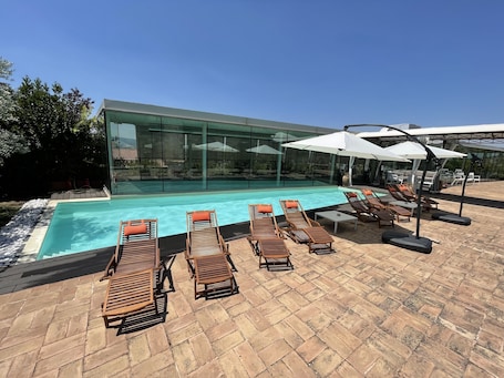 Una piscina al aire libre de temporada, sombrillas