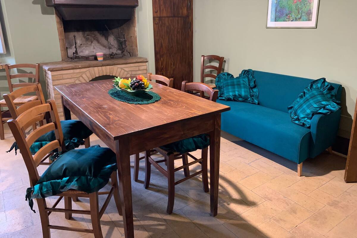 Un comedor con una mesa de madera, sillas y un sofá azul.