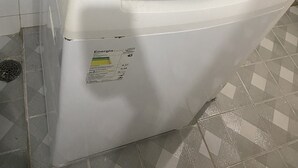 Een voorlader wasmachine met een bedieningspaneel, een stroomkabel en een label dat het energieverbruik aangeeft.