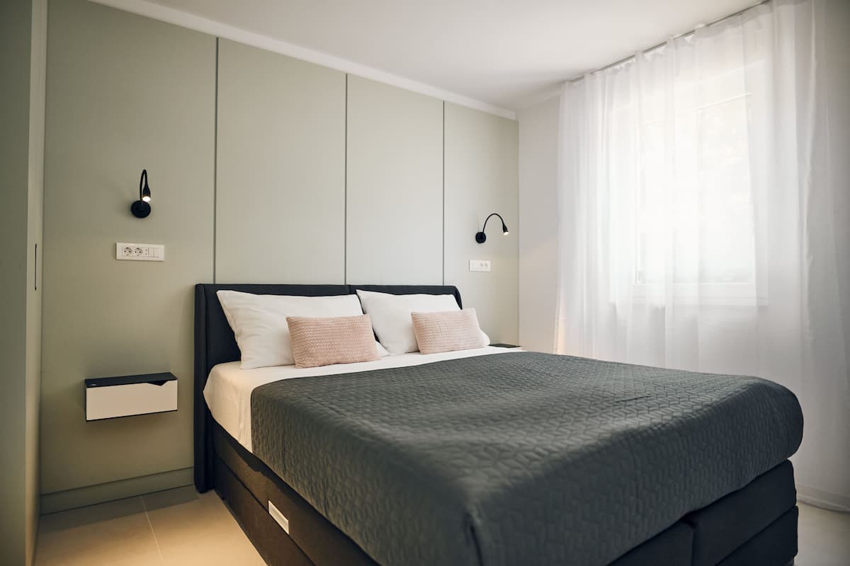Ein modernes Schlafzimmer mit Bett, Nachttischen und Wandleuchten.