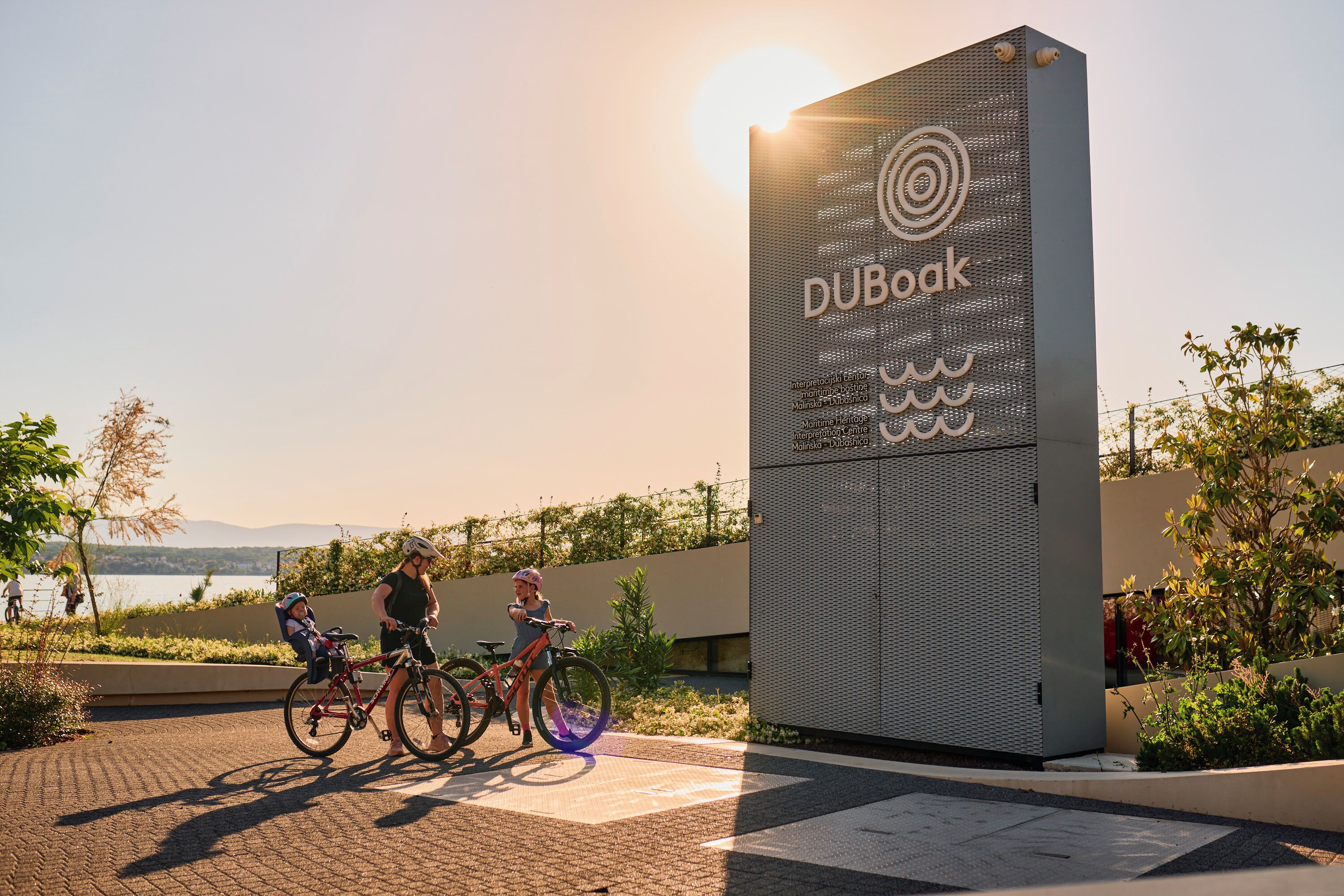 A modern building with a sign that reads "DUBOAK" and a bicycle parking area.