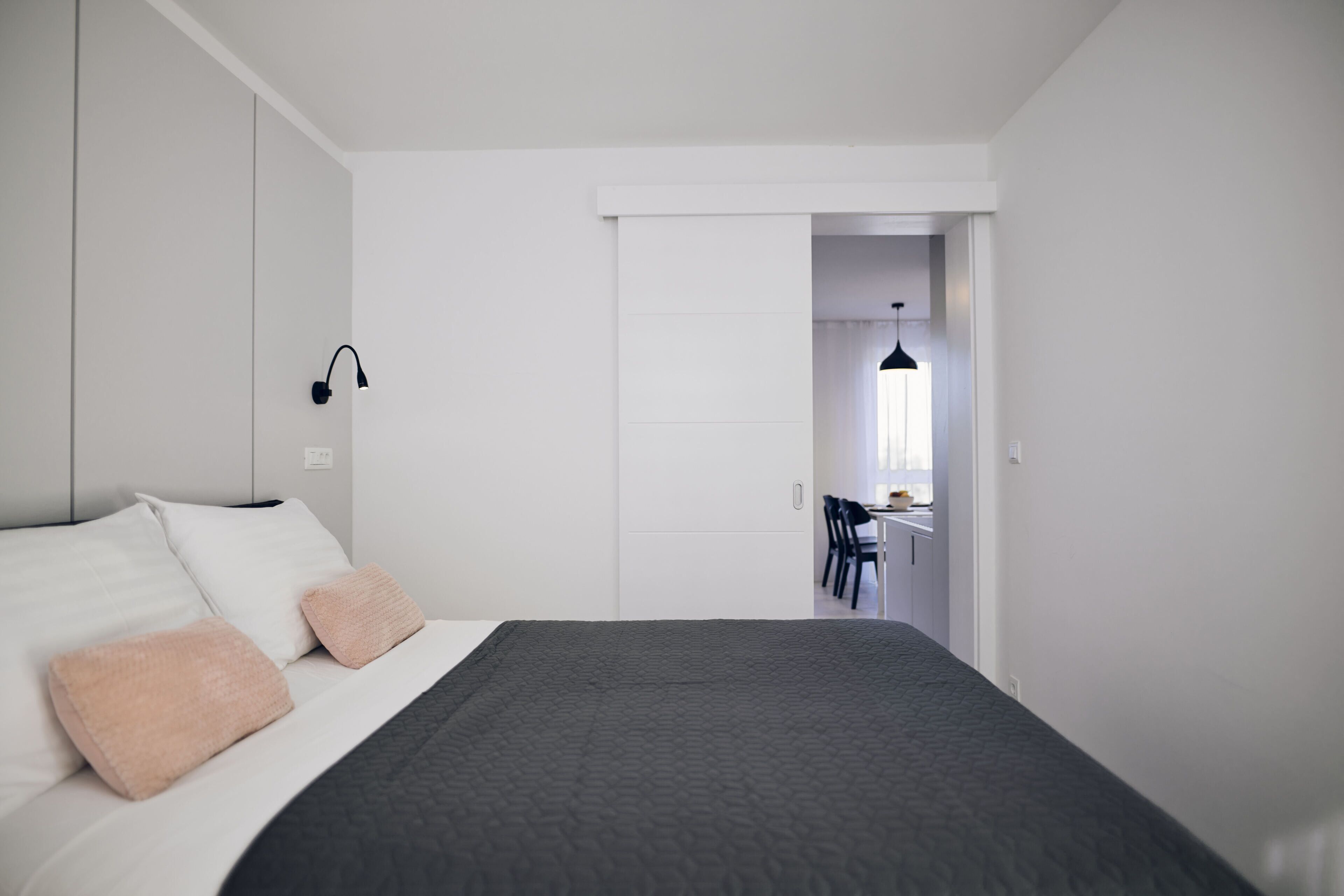 Ein modernes Schlafzimmer mit einem Bett, einem Schreibtisch und einem Stuhl im Hintergrund.