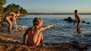 A beach scene with people playing in the water. - Malinska Green Apartments (Malinska-Dubasnica)