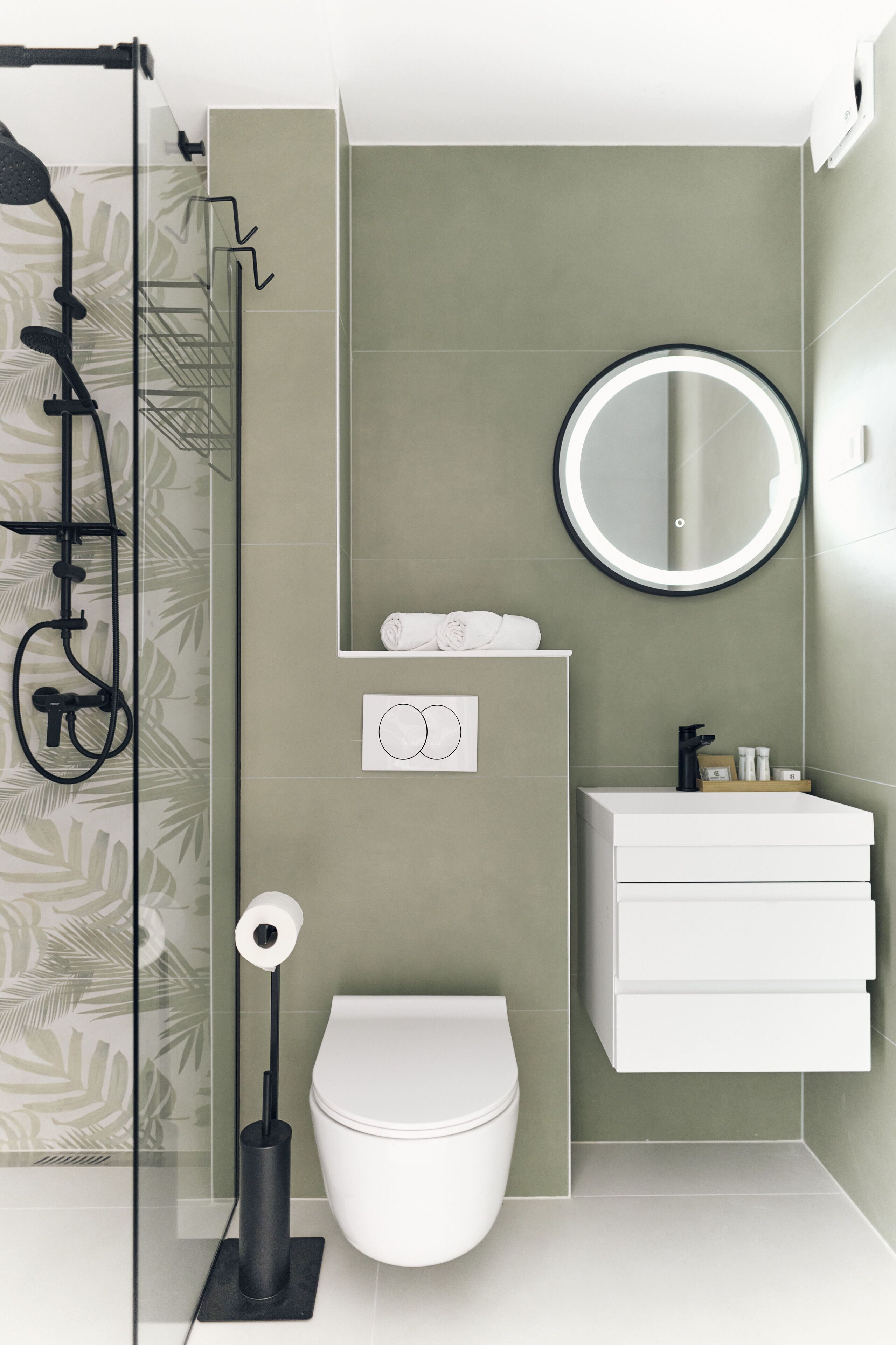 A modern bathroom with a toilet, sink, and shower.