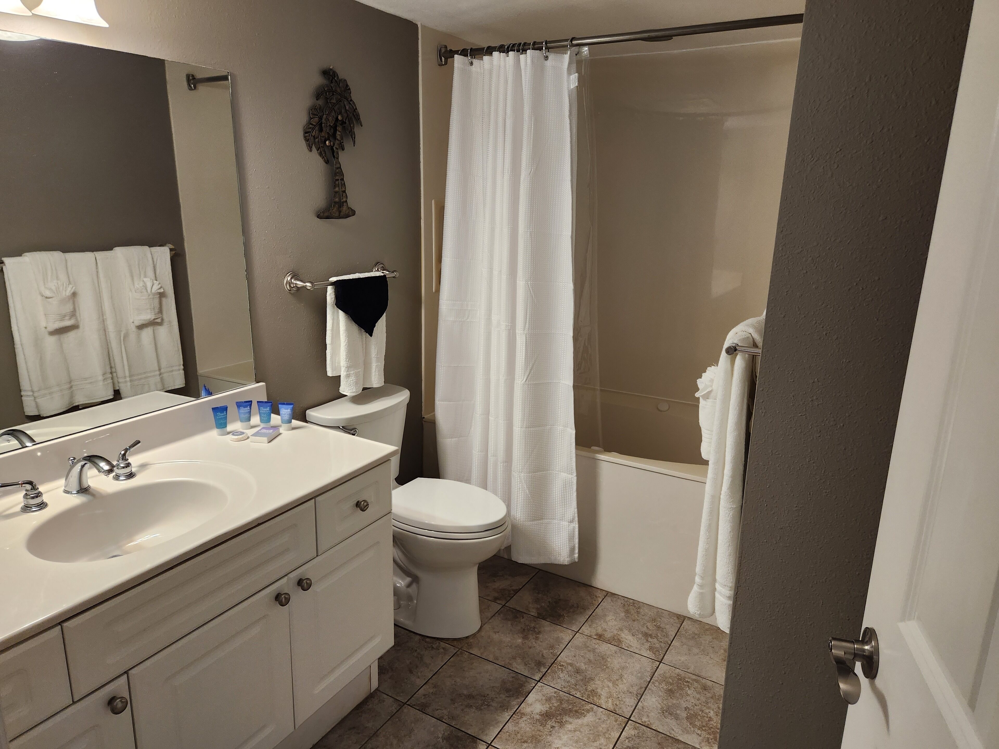 A bathroom with a sink, toilet, and shower curtain.