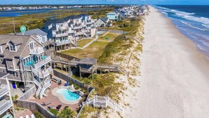 A coastal residential area with houses, a beach, and a swimming pool.
