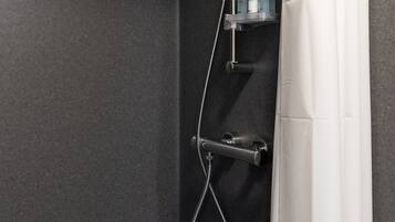 Eine Dusche mit Handbrause, Wandarmatur und Bedienfeld.