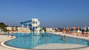 A swimming pool with a water slide, lounge chairs, and umbrellas. - Caci-C2 with Pool - istriensonne 0736 (Medulin)