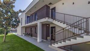 A modern building with a two-story structure, a covered outdoor seating area, and a staircase leading to the upper floor. - Caci-C2 with Pool - istriensonne 0736 (Medulin)