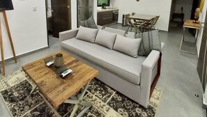 Un salon moderne comprenant un canapé, une table basse et un coin repas avec des chaises et une table.