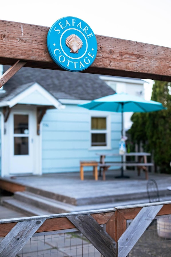 A wooden fence with a sign that reads "Seafare Cottage." - Seafare (Seaside)