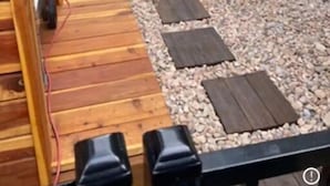 Un'area esterna con mobili da giardino, un vaso e un sentiero acciottolato.