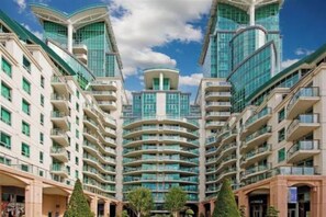 Un immeuble résidentiel de grande hauteur doté de nombreux balcons et d’un atrium central.