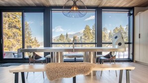Een modern interieur met een grote eettafel, twee stoelen en een bank.
