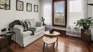 A living room with a sofa, a coffee table, and a window with curtains. - Fun, family friendly stay in Niagara Falls (Niagara Falls)