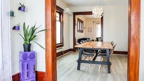 A room with a wooden floor, a dining table with chairs, a ceiling light, and a door leading to another room. - Fun, family friendly stay in Niagara Falls (Niagara Falls)