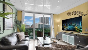 A modern living room with a sofa, armchairs, a coffee table, and a TV on a cabinet. - Direct access to beach and heated pool at The Tides (Hollywood)