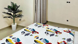A room with a bed, an air conditioning unit, a potted plant, and a curtain. - Cozy Room In Cotonou City
 (Cotonou)