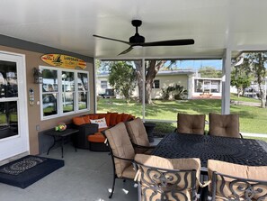 A covered patio area with outdoor furniture, a ceiling fan, and a view of the backyard. - Waterfront Bungalow with private mooring, slip, kayaks, deep water canal (Homosassa)