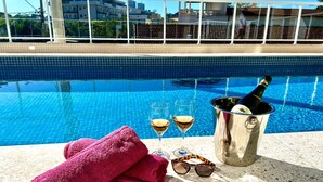 A poolside setting with a champagne bottle, glasses, and a pink towel. - Brisamar (Ubatuba)