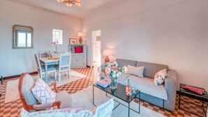 A living room with a sofa, a coffee table, and a dining area with a table and chairs. - Gordes Idyllique Avec vue Panoramique (Gordes)