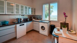 A compact kitchen with a washing machine, a sink, and cabinets. - Gordes Idyllique Avec vue Panoramique (Gordes)
