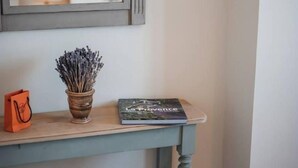 A corner with a light blue console table, a small potted lavender plant, a book, and an orange bag. - Gordes Idyllique Avec vue Panoramique (Gordes)
