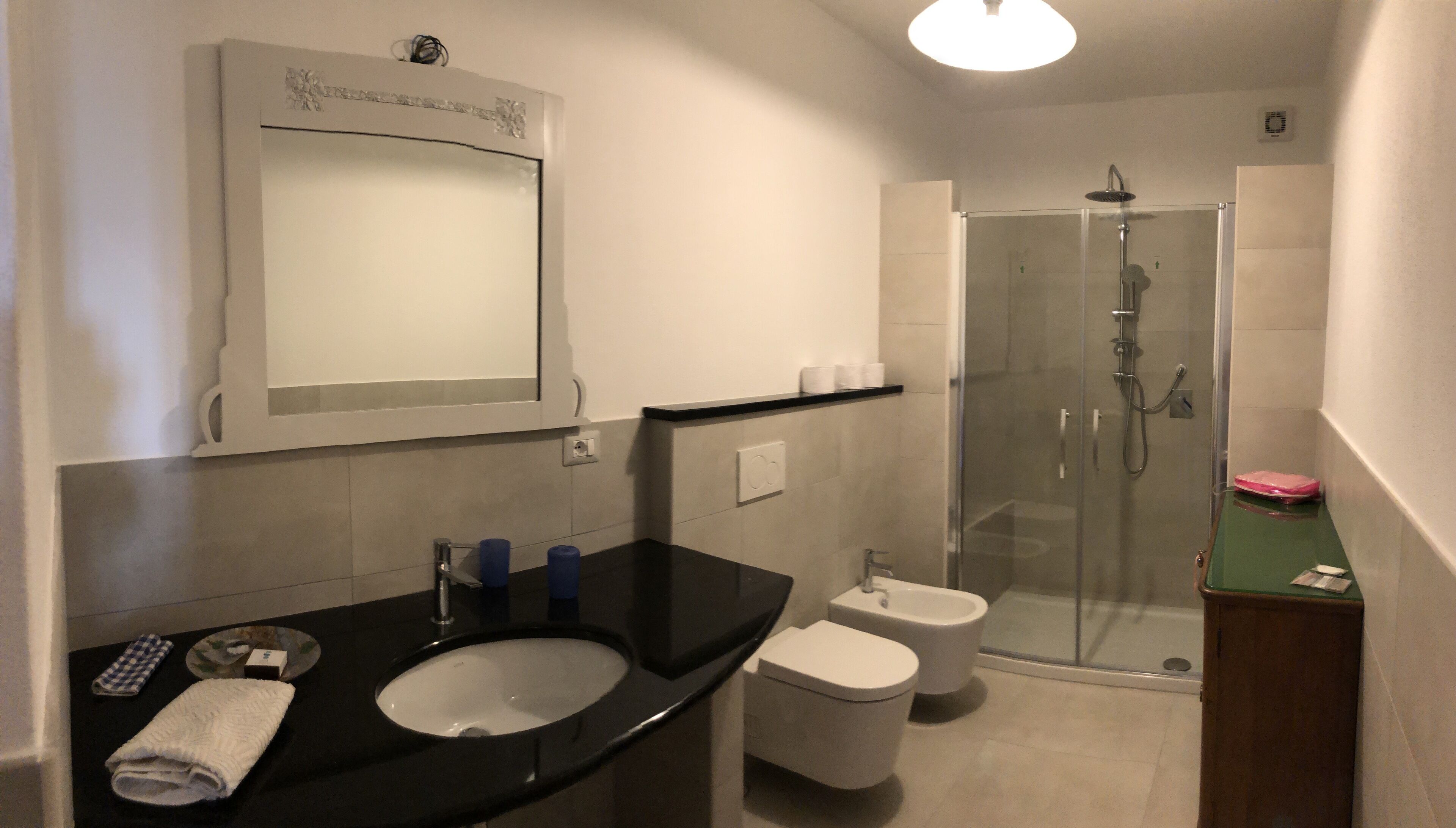 Une salle de bain équipée d’un lavabo, de toilettes et d’une douche à parois de verre.