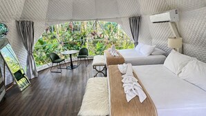 Una habitación con una cama grande, una banca, una lámpara colgante y vistas a zonas verdes.