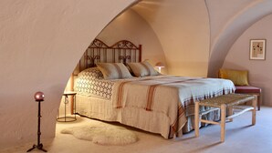 A cozy bedroom with a bed, a bedside table, a lamp, and a bench. - Antica Masseria le Monache (Grottaglie)