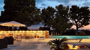 A poolside area with lounge chairs, an umbrella, and a pool. - Antica Masseria le Monache (Grottaglie)