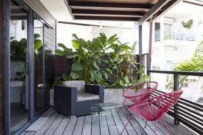 Enjoy a peaceful retreat on this balcony with a glass-top table and comfortable seating for two.