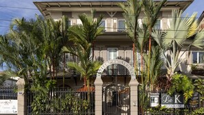 Un hotel de estilo arquitectónico clásico, con una entrada arqueada destacada y el letrero de 'Le K Restaurant' a la derecha.