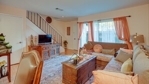 A living room with a sofa, a television, a wooden cabinet, and a staircase. - Lovely Concord Townhome Retreat w/ Community Pool! (Concord)
