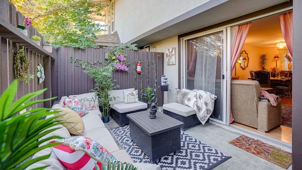 An outdoor patio with wicker furniture, a fire extinguisher, and a sliding glass door leading to an interior space. - Lovely Concord Townhome Retreat w/ Community Pool! (Concord)