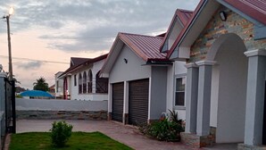 A residential building with a paved driveway, a small lawn, and a brick wall. - 4 Bedrooms Family House Sakumono (Sakumono)