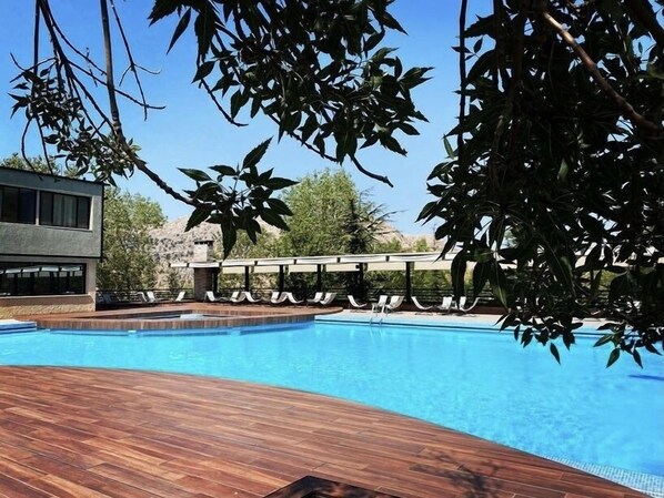 Relax by the pool surrounded by lush greenery and enjoy the serene atmosphere.