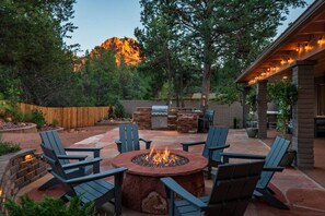 An outdoor patio with a fire pit, seating, and a grill area. - Enchanted Forest de Sedona: TV-Featured Hot Tub & Red Rock Views (Sedona)