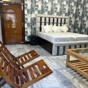 Relax in this stylish room with a comfortable bed, geometric-patterned headboard, and two chairs.