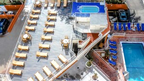Eine Terrasse mit Liegestühlen, einem Pool und einer kleinen Sitzecke.
