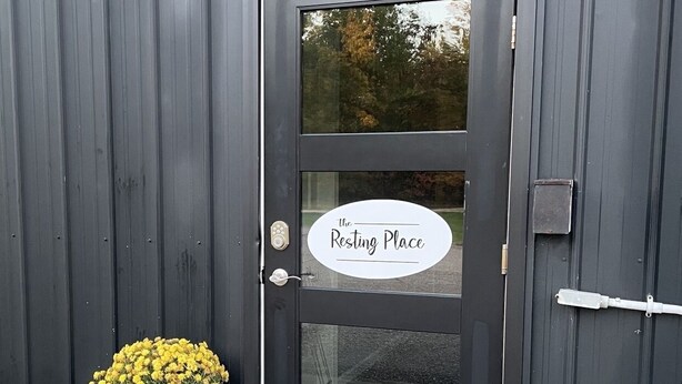 A black door with a frosted glass panel and a sign that reads "the Resting Place." - The Resting Place Apt 1  Keep it simple at this peaceful & centrally located Apt (Marion)