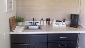 A kitchen with a coffee bar, a sink, and three pendant lights. - The Resting Place Apt 1  Keep it simple at this peaceful & centrally located Apt (Marion)